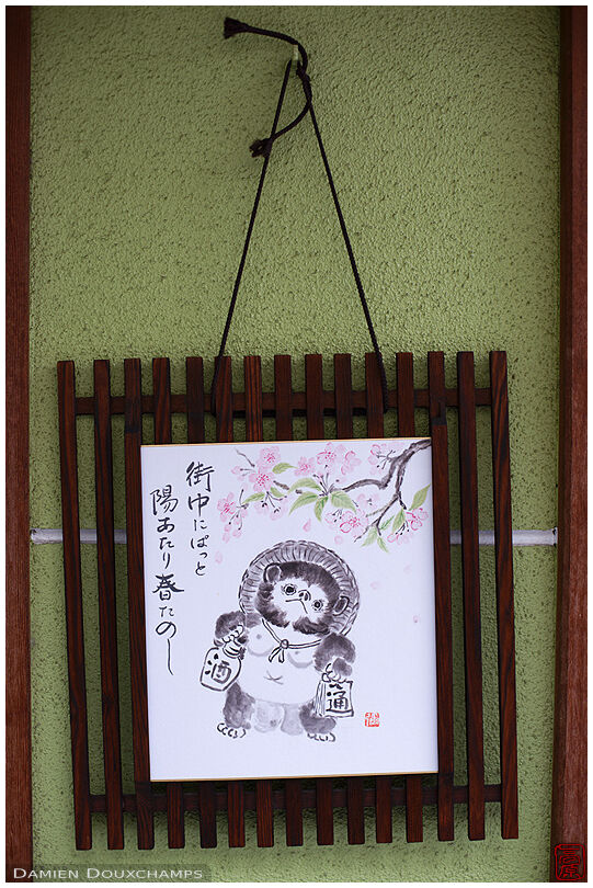 Seasonal poem and tanuki painting at the entrance of a private home in Kyoto, Japan