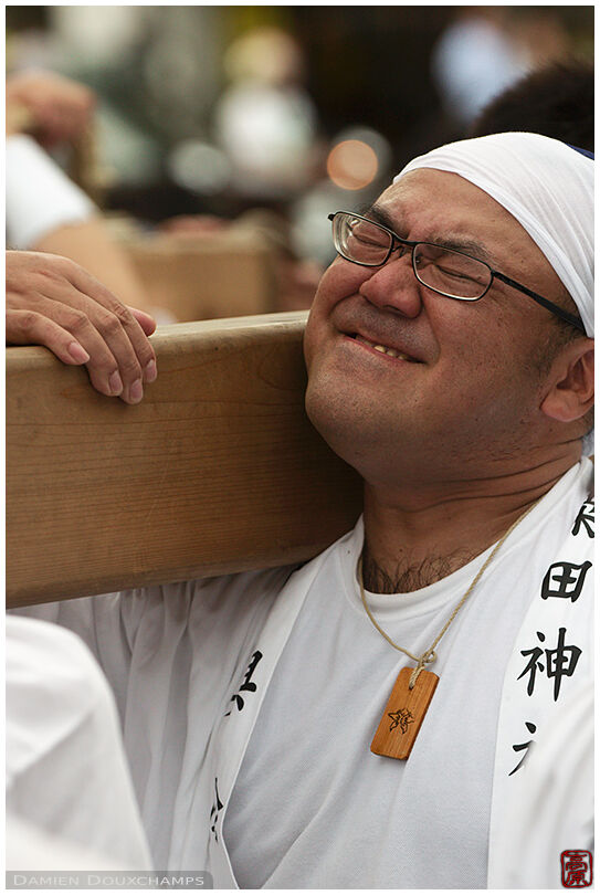 Man struggling to carry a float during a festival in Gion (祇園)
