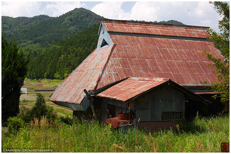 Old thatched farm house covered with rusty iron panels in Wakayama countryside, Japan