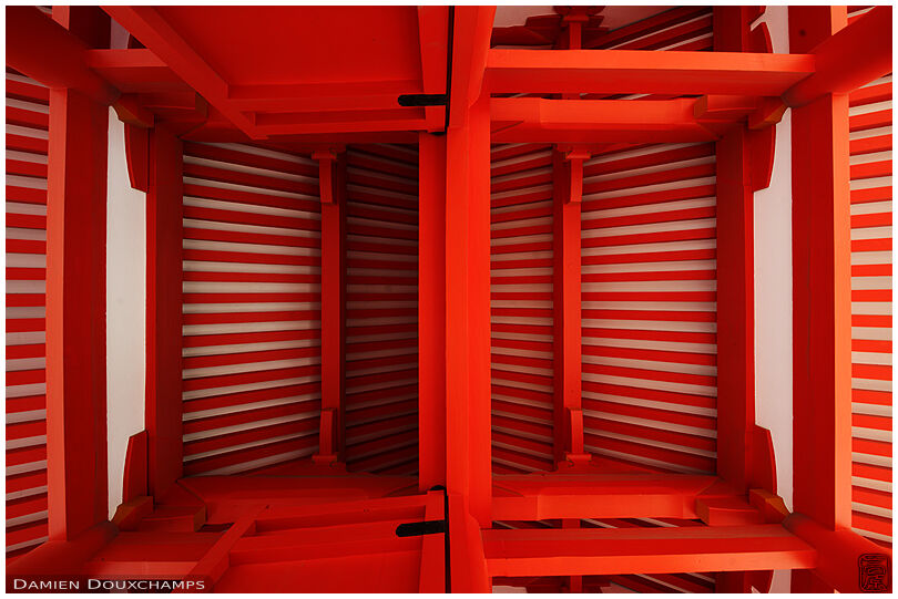 Inner roof structure of a bright orange gate in the Imperial Palace, Kyoto, Japan