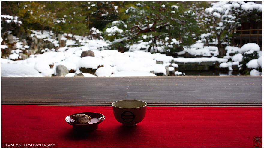 Green maccha tea and sweet with view on snow-covered zen garden, Toji-in temple, Kyoto