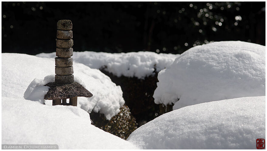 Little stone pagoda peeking through the snow in Shisen-do temple, Kyoto, Japan