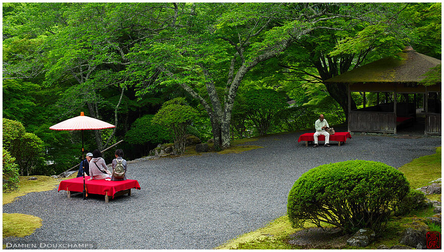 Visitors resting during springtime in the Hakuryu-en garden, Kyoto, Japan
