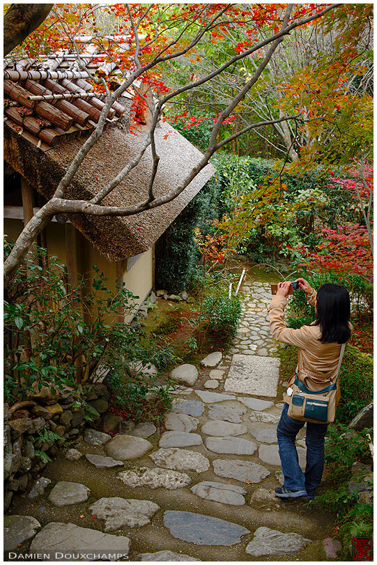 Photographing the little thatched-roof hut at the entrance of the Enri-an temple, Kyoto, Japan