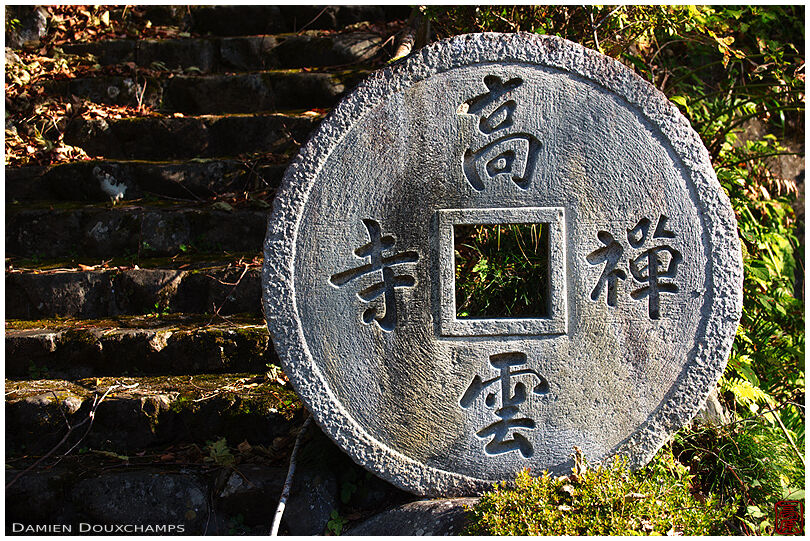 Large round stone with square hole as entrance sign to Koun-ji temple, Kyoto, Japan