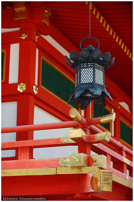 Stone lantern and typical shinto architecture with bright orange colors, Iwashimizu Hachiman-gū, Kyoto, Japan