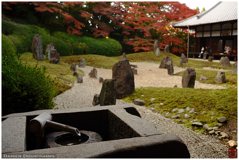 Tsukubai water basin with little stubby bamboo fountain in the rock garden of Komyo-in temple, Kyoto, Japan