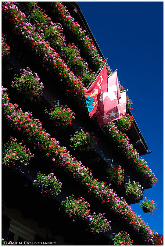 Flowered facade with flags of Zermatt, Switzerland and the Valais region.