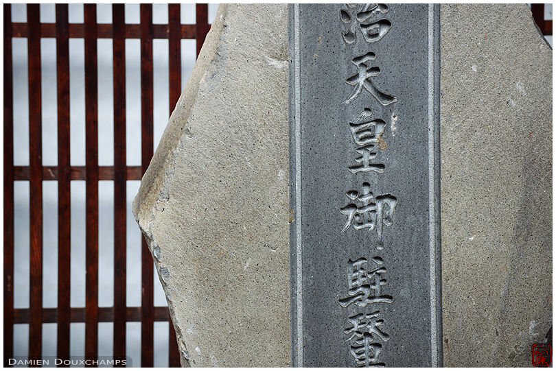 Carved stone in front of traditional wooden facade