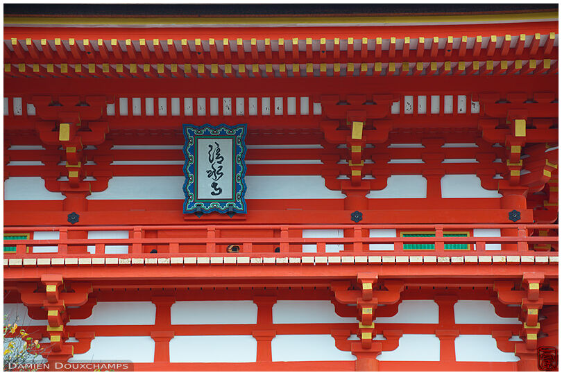 Traditional white and orange patterns on the upper section of the main gate