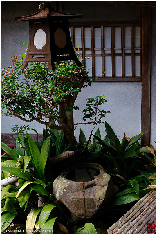 Rusty lantern and old tsukubai wash basin in a garden of Jurin-ji temple, Kyoto, Japan