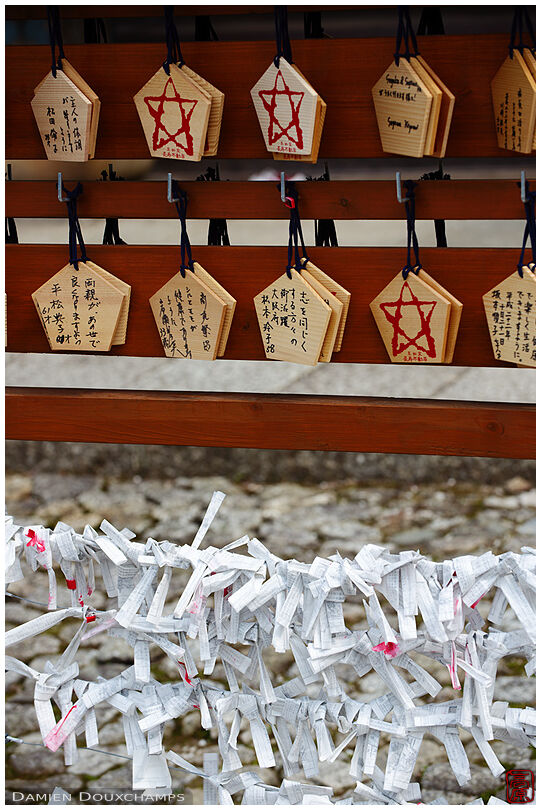 Ema votive offerings and tied umikuji fortunes in Shinyo-do temple
