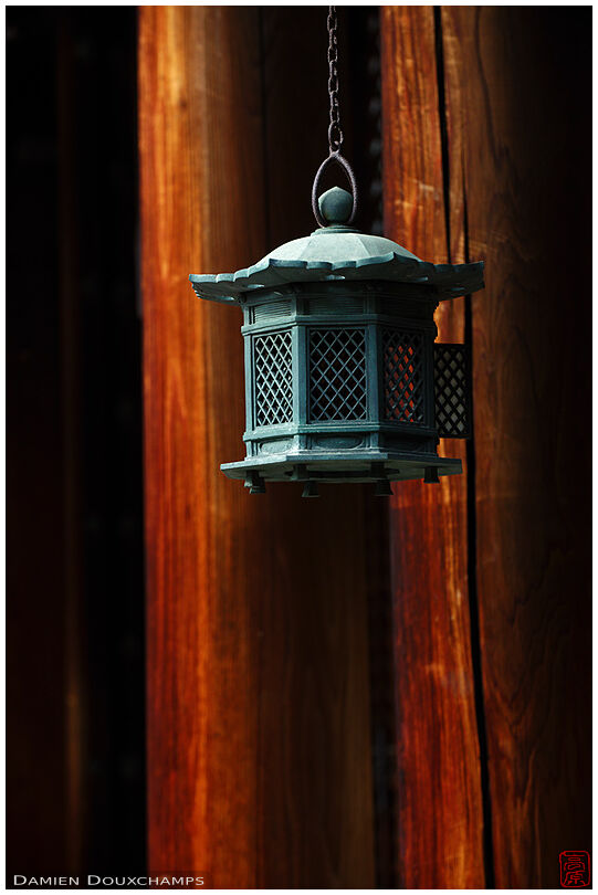 Metallic lantern among red wood pillars, Hinotanjo-in temple