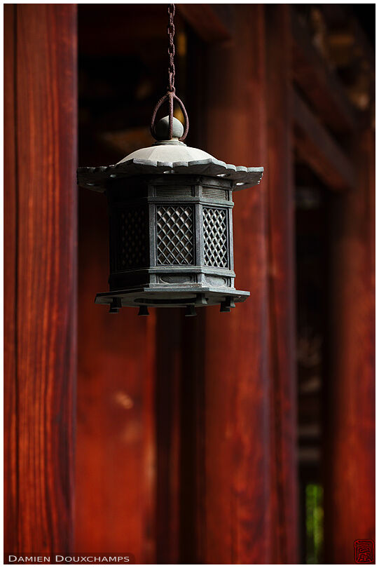 Metallic lantern among red wood pillars, Hinotanjo-in temple