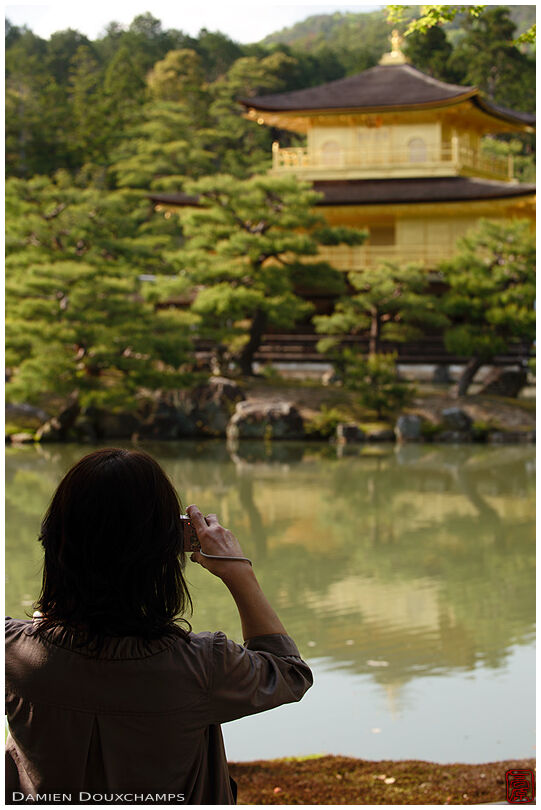Tourist photographying the Golden pavilion, Kinkaku-ji temple
