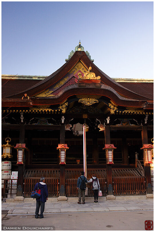 Couple shaking the shrine bell to call the gods, Kitano Tenmangu shrine