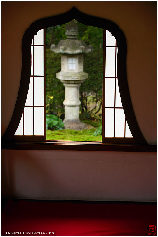 Flower-shaped window with view on stone lantern, Tentoku-in temple