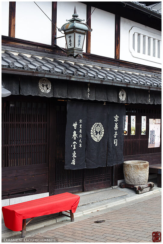 Red bench and hanging noren cloth for a traditional shop in Kyoto, Japan