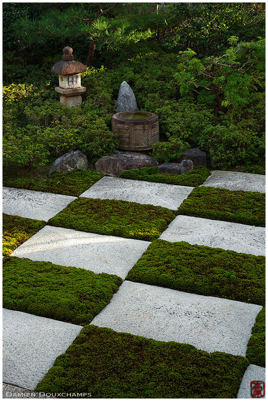 Moss and stone chessboard pattern zen garden with tsukubai water basin and cute little stone lantern in Daito-in temple, Kyoto, Japan