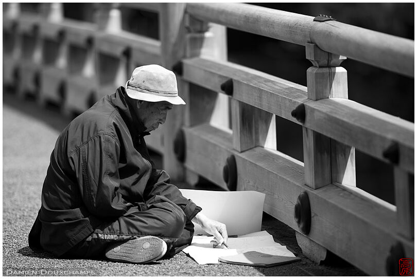 Artist drawing on the Itsukushima shrine bridge in the imperial palace gardens, Kyoto, Japan