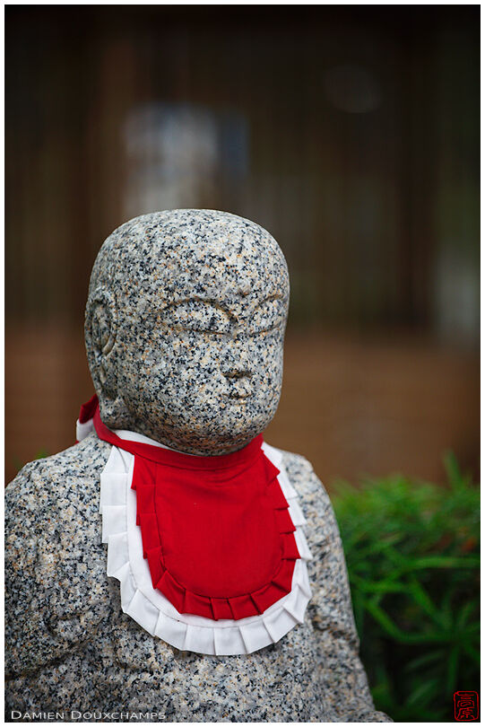 Stone jizo statue with red and white bib, Kyoto, Japan