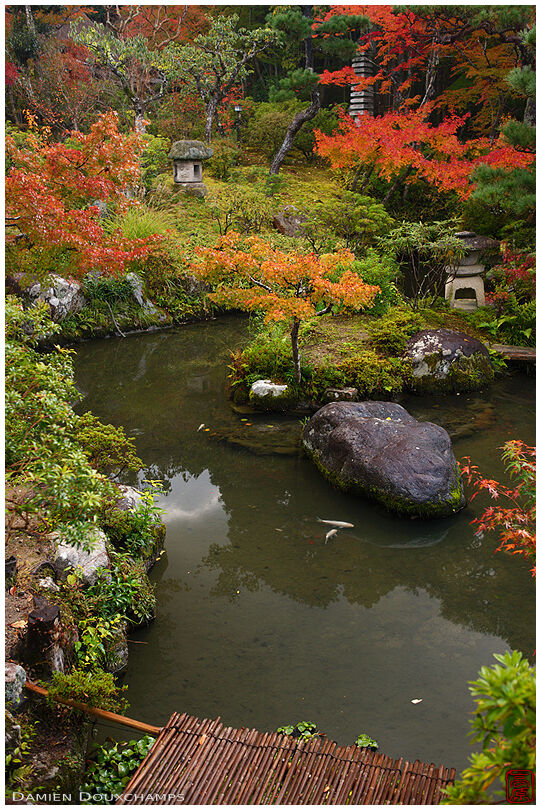 Pond with stone lanterns surrounded by autumn colours, Yoshiki-en garden, Kyoto, Japan