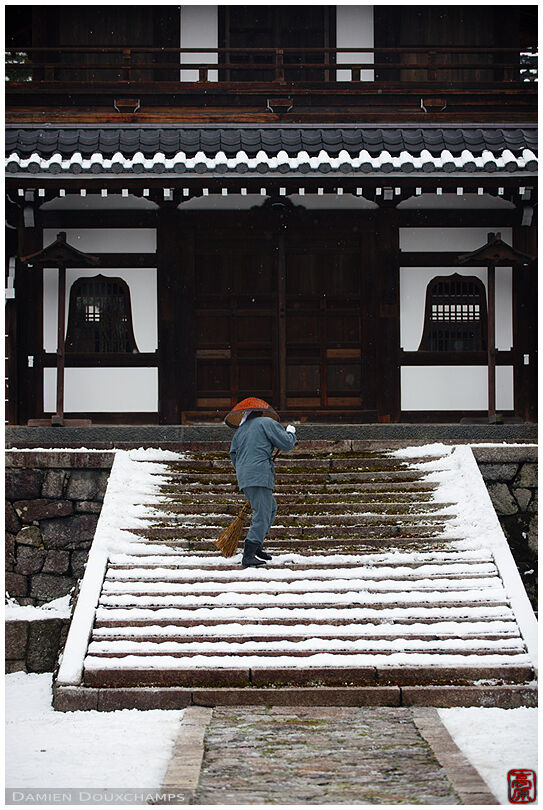 Monk clearing snow in front of Kennin-ji temple Founder's Hall, Kyoto, Japan