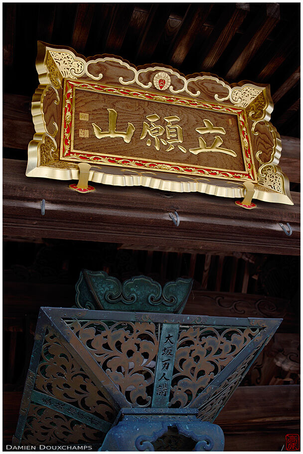 New golden sign over old rusty iron lantern in Yokoku-ji temple, Kyoto, Japan