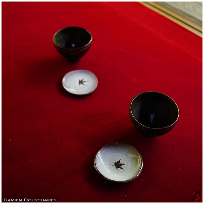 Tea bowls over red carpet, Keishun-in temple, Kyoto, Japan