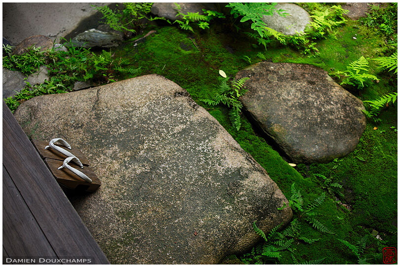 Sandals left on stepping stones at edge of moss garden, Watchigai-ya, Kyoto, Japan