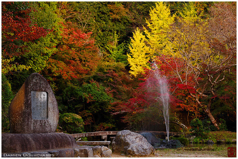 Old stone and fountain amidst autumn colours in Miyakehachiman shrine, Kyoto, Japan