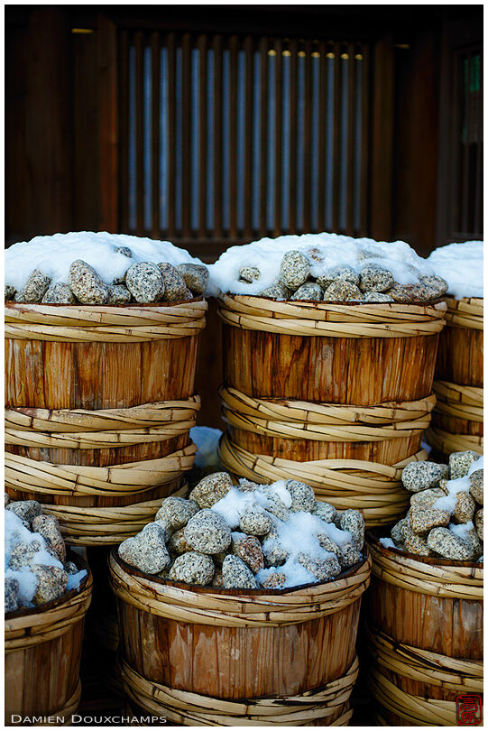 Snow covering buckets filled with stones, Shimogamo shrine, Kyoto, Japan