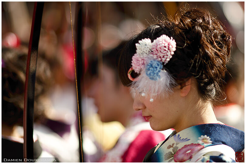 Young female archer in kimono with flowers in her hair during the Sanjusangendo temple Toshiya archery competition, Kyoto, Japan