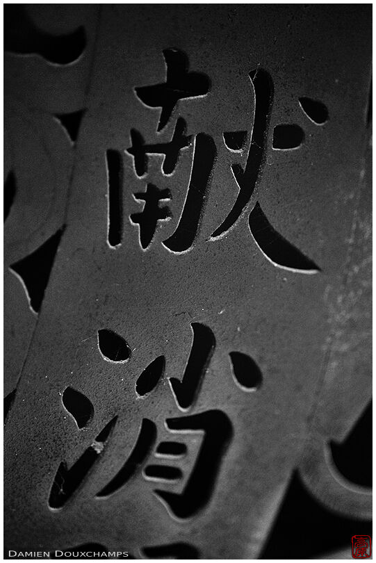 Detail of kanji characters punched in steel lantern, Uho-in temple, Kyoto, Japan