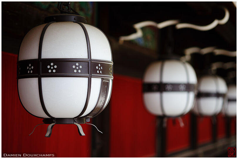 Row of lanterns adorning a wall in Kitano Tenmangu shrine, Kyoto, Japan
