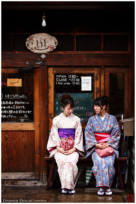 Two ladies in kimono waiting at the entrance of a cafe built in an old public bath, Kyoto, Japan