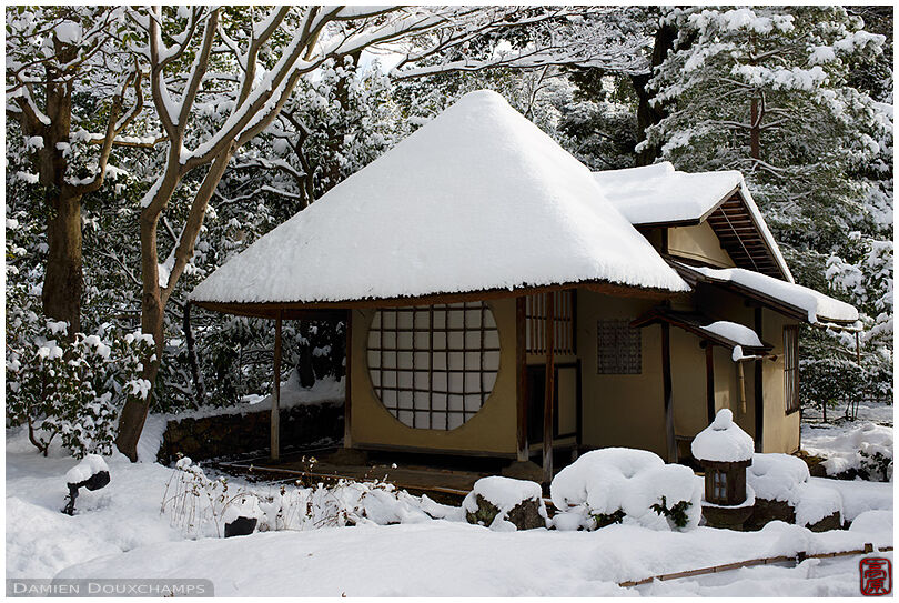 Small tea house with large round window covered in snow, Kodai-ji temple, Kyoto, Japan