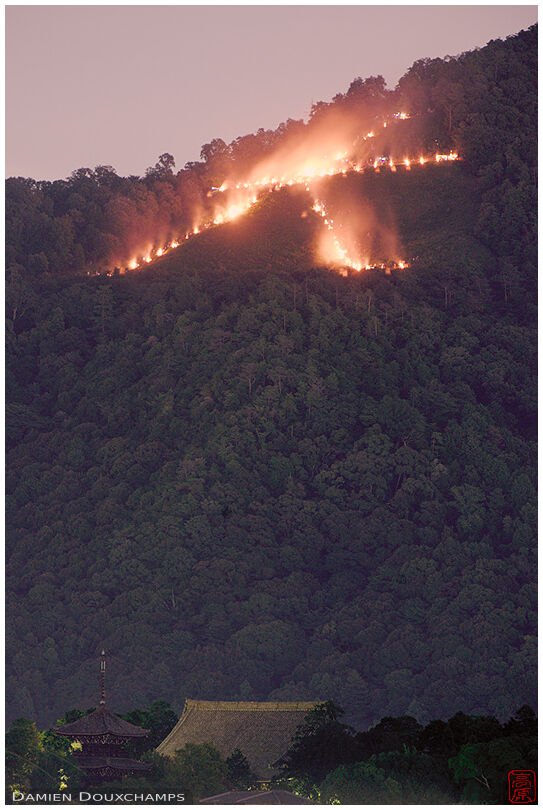 Fires on the Daimonji mountain over Shinyo-do temple buildings, Kyoto, Japan