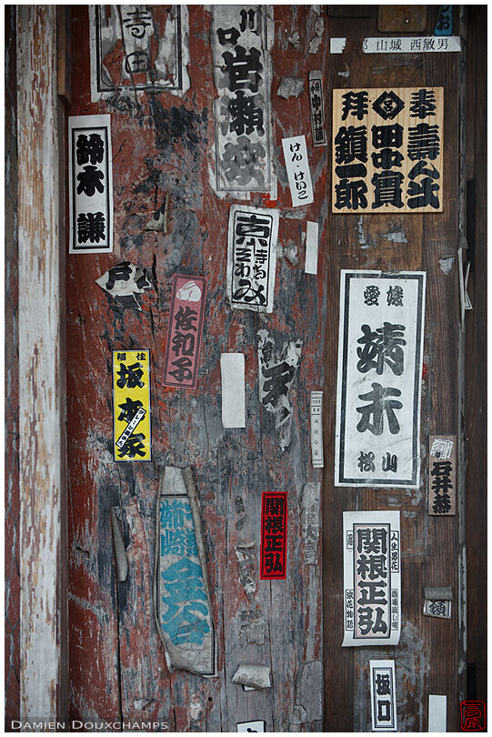 Various stickers of pilgrims and other visitors on the gate of Anao-ji temple, Kyoto, Japan