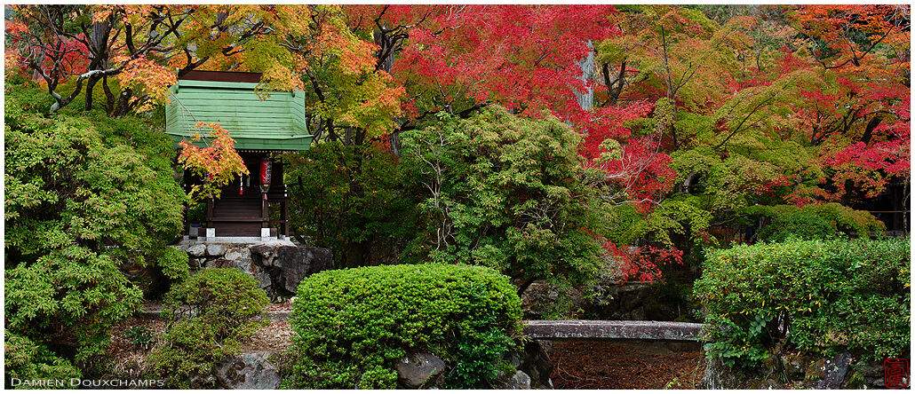 Stone bridge leading to small shrine in early autumn, Shinyo-do temple, Kyoto, Japan