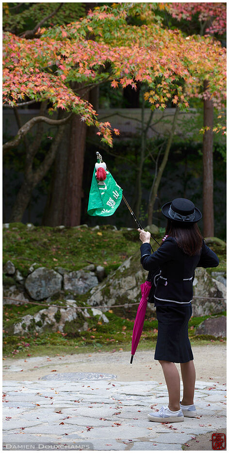 Female tour guide with flag in Kongorin-ji temple, Kyoto, Japan