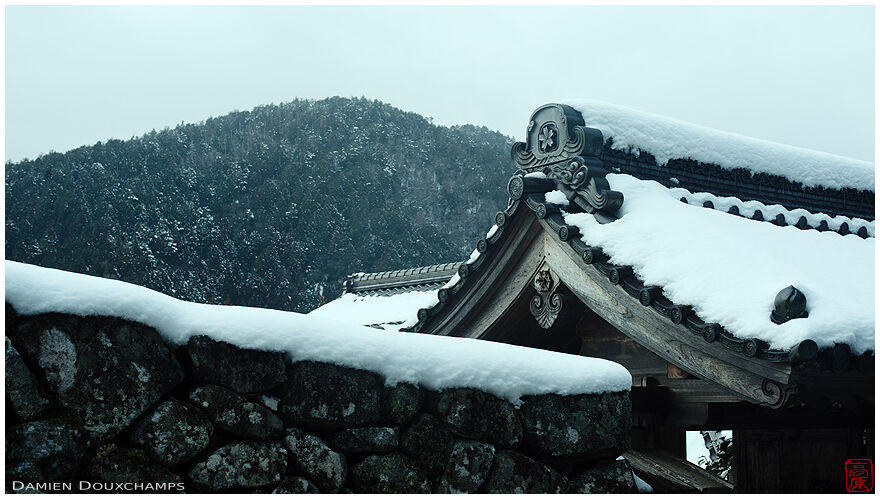 Snow covered wall and entrance gate to Jikko-in temple on a cold winter day, Kyoto, Japan