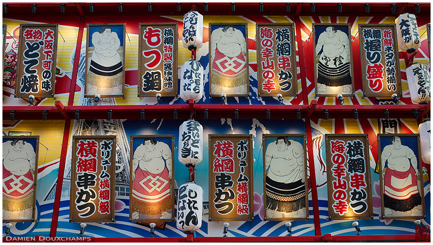 Paper lanterns and sumo signs on the façade of a restaurant in Shinsekai, Osaka, Japan