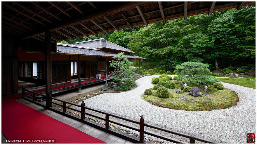 Covered walkway with red carpet around dry landscape garden, Manshuin temple, Kyoto, Japan