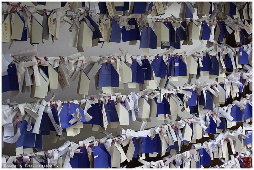 Tied discarded fortunes and blue votive offerings in Ishiyama-dera temple, Kyoto, Japan