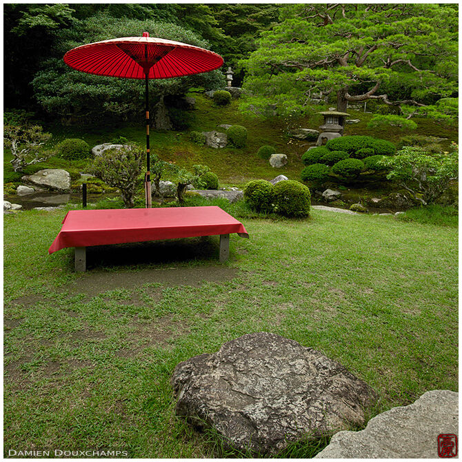 Red bench and umbrella in the garden of Chikurin-in in Shiga, Japan