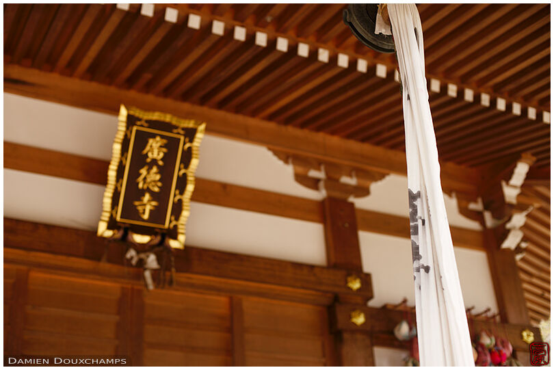 Bell rope, temple sign and recently renovated wooden architecture in Kotoku-ji temple, Shiga, Japan