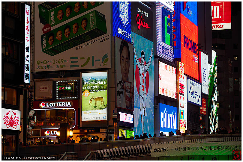 Building completely covered with colorful advertisements around the Dotombori bridge in Osaka, Japan