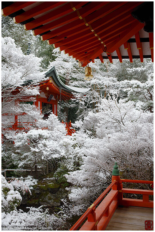 Snow-covered trees and red buildings in Bishamon-do temple, Kyoto, Japan