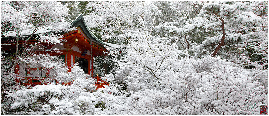 Little red hall hiding among the snow-covered trees in Bishamon-do temple, Kyoto, Japan